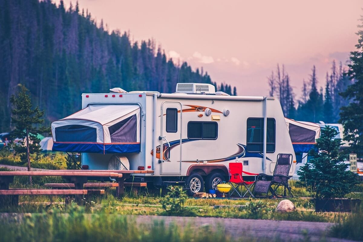 A pop camper travel trailer parked at an RV campsite.