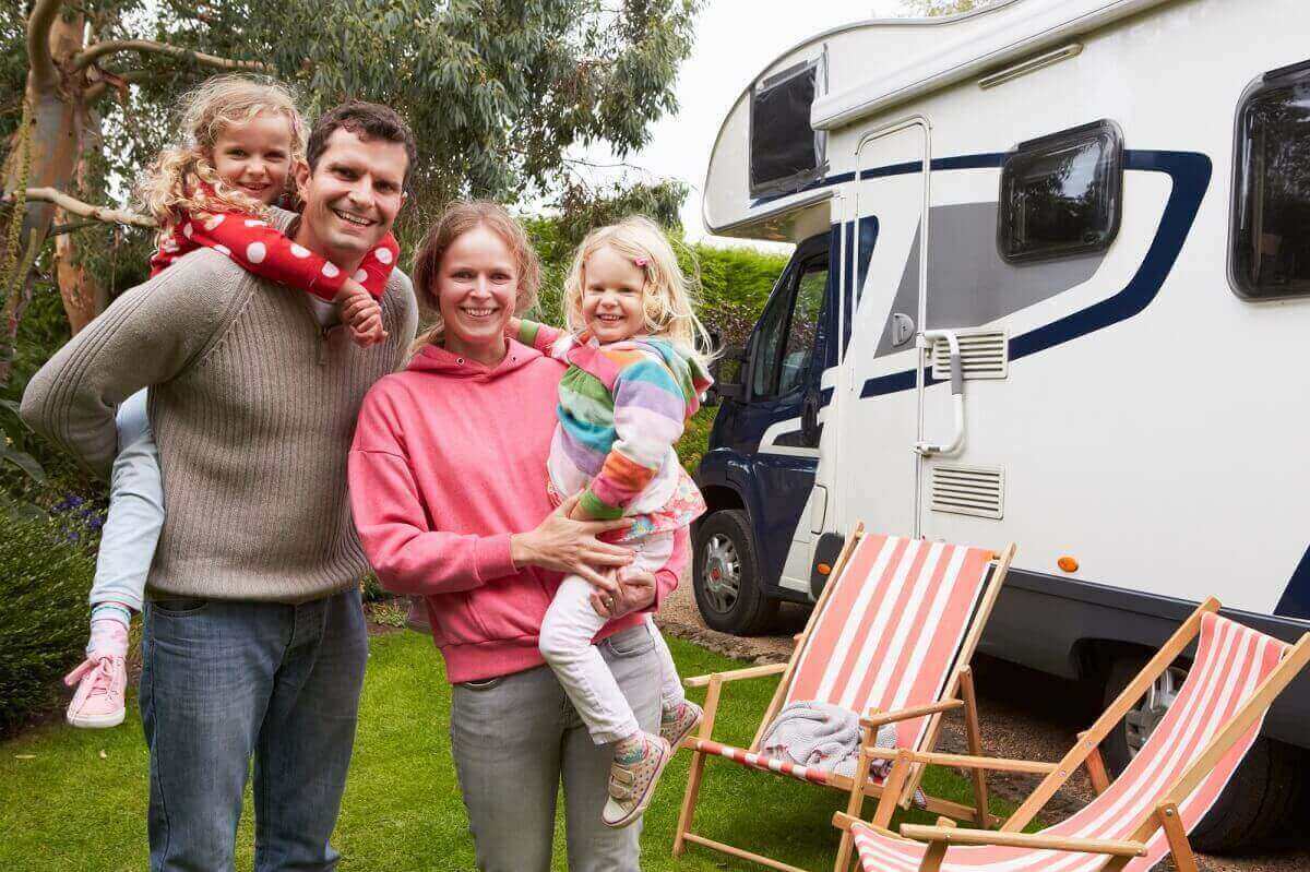 Family of four in front of an RV Motorhome