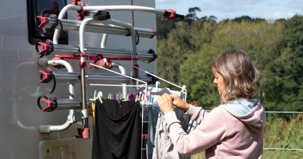 A lady motorhome owner doing laundry and hanging washing on her bike rack to dry