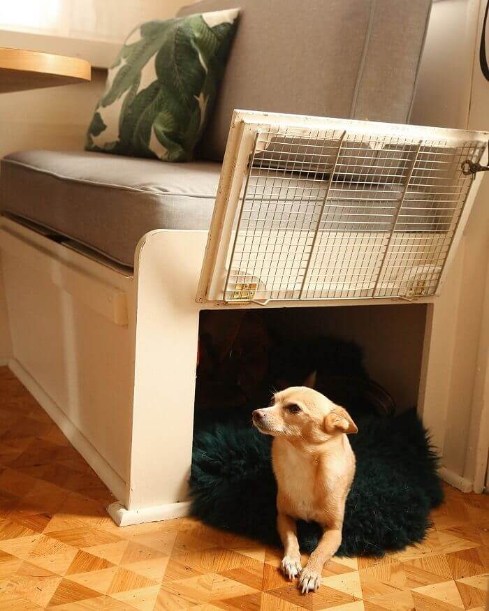 A small pup inside a homemade built dog kennel